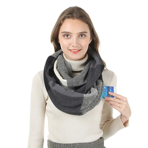 Detail showing the hidden zipper pocket on a color-block knit scarf for storing smartphones