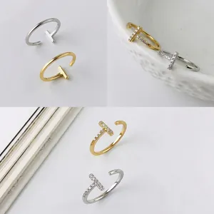 Detail of minimalist S925 silver T-shape open rings in gold and silver with zircon accents
