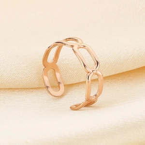 Detailed view of rose gold hollow chain ring on elegant silk fabric background