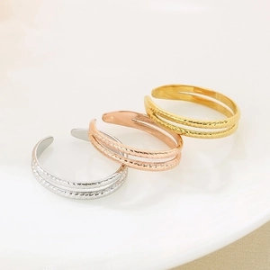 Detail view of triple-finish wide band rings with twisted rope texture in steel