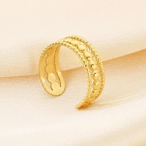 Detail of adjustable gold ring with irregular texture on champagne silk background