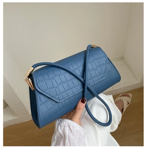 Detail of blue crocodile pattern shoulder bag with premium gold metal hardware link