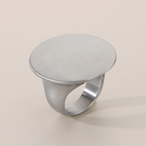 Detail of silver round flat signet ring with brushed metal texture and mirror polish finish