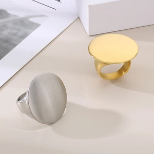 Detail of round flat surface minimalist rings in polished gold and silver finishes