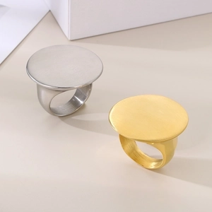 Minimalist gold and silver stainless steel oval disc rings with brushed metal texture