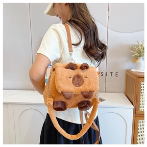 Close-up of a plush Capybara crossbody bag worn by a model to show size and texture