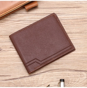 Close-up of brown leather wallet with lychee texture and fine stitching on wooden desk