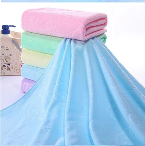 Close-up of soft coral fleece towels with embossed bear patterns in multiple pastel colors