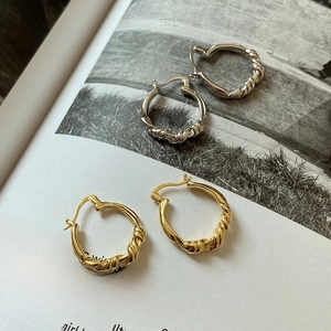 Close-up of twisted rope texture on S925 sterling silver hoop earrings in gold and silver