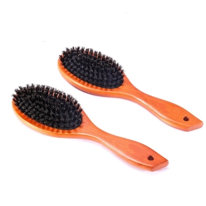 Detailed close-up of two wooden hair brushes with soft black bristles and hanging holes