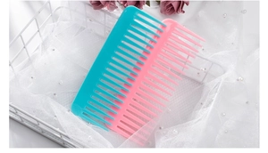 Detailed close-up of colorful wide-tooth hair combs in a decorative white basket