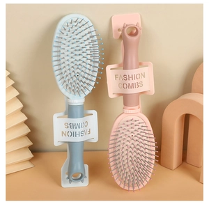 Detailed view of pink and blue hair brushes with hanging hooks and fashion packaging