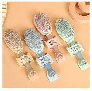 Detail of four colorful portable hairbrushes with animal ear handles on warm background