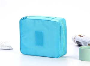 Detail of light blue travel toiletry bag with woven texture and top handle
