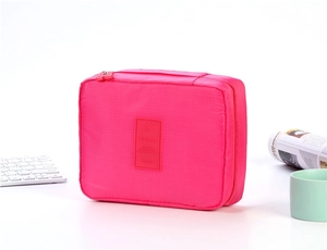 Close-up of rose red nylon travel toiletry bag with zipper and top handle detail