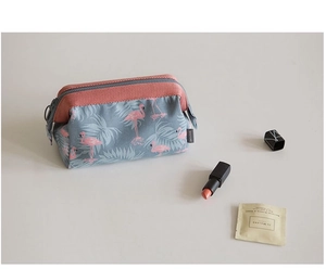 Detail of pink flamingo pattern fabric on a blue travel cosmetic bag with zipper
