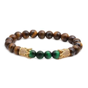 Tiger eye and cat eye beaded bracelet with golden crown accents on white background