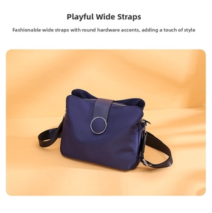 Detail of dark blue nylon crossbody bag featuring a silver metal ring accent and strap