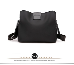 Back view of a multi-layer black nylon crossbody bag with adjustable straps and waterproof texture