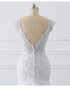 Close-up of white lace fisheye wedding dress with deep V-back and pearl button details