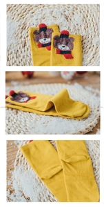 Detail of yellow cotton socks featuring a 3D embroidered brown bear with a red scarf