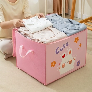 Detail of pink cartoon rabbit storage box with side handles being filled with clothes