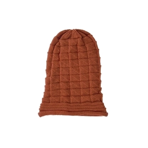Macro detail of caramel knit beanie showing textured checkered pattern and soft fabric