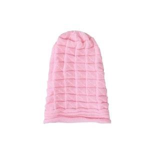 Close-up of pink knitted beanie showing soft checkered texture and folded cuff detail