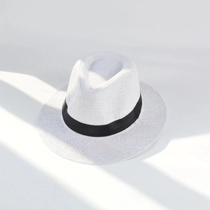Detailed view of woven straw sun hat texture with minimalist black decorative band