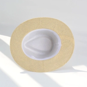 Detail view of woven straw hat interior featuring sweatband and white inner lining