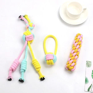 Detailed macro of pink and yellow cotton rope pet chew toys in three various shapes