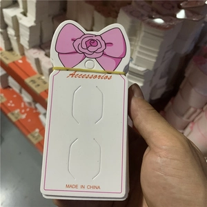 Pink bow cardboard hair clip display card with two pre-cut slots for earrings