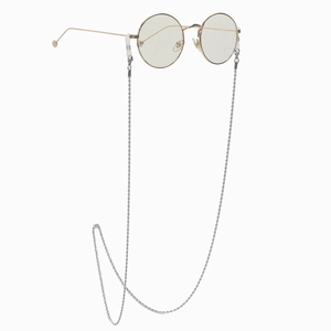 Chaîne à lunettes argentée torsadée avec monture ronde dorée sur fond blanc pur