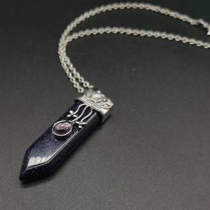 Macro detail of hexagonal blue sandstone pendant with intricate silver metal mounting
