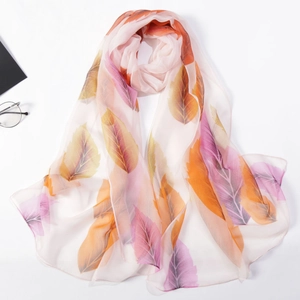 Detail of lightweight chiffon scarf featuring vibrant orange and purple leaf prints