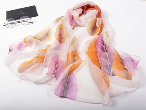 Close-up of lightweight chiffon scarf featuring vibrant autumn leaf patterns in orange and purple