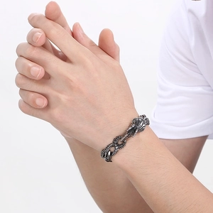 Detailed close-up of punk dragon head buckle and scale-textured steel bracelet