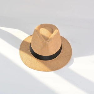 Detailed top view of natural straw panama hat featuring elegant striped shadow effect