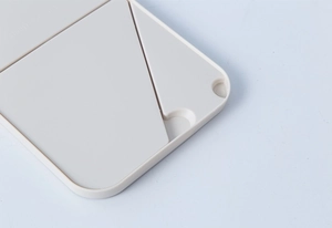 Detailed close-up of cream white portable folding makeup mirror frame and hinge structure