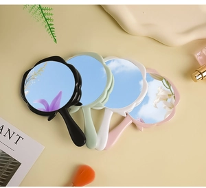 Flat lay of flower-shaped handheld makeup mirrors in multiple colors with beauty props