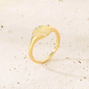 Macro shot of 18K gold plated sunflower signet ring with sunburst pattern on stone