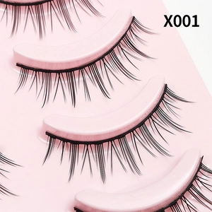 Detailed view of natural wispy false eyelashes on a pink tray, model X001