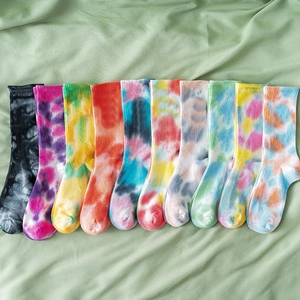 Tie-dye ribbed mid-calf socks in various colors displayed on a soft green background