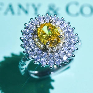 Macro view of a luxury ring featuring an oval yellow gemstone with double halo diamond setting