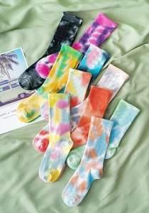 Flat lay view of colorful tie-dye crew socks in various vibrant cotton blend patterns
