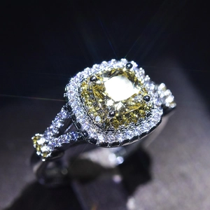 Macro shot of cushion cut yellow gemstone ring with double halo diamond setting