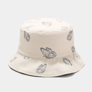 Détail du motif papillon sur un chapeau bob en coton réversible pour femme crème