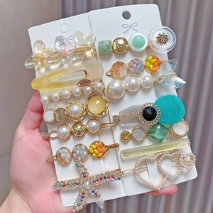 Close-up of 8-piece pearl hair clip set with rhinestone butterflies and resin heart charms