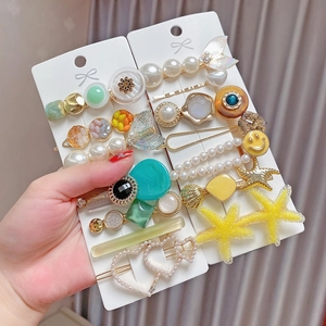 Detail of 8-piece hair clip set featuring pearl, starfish, shell and heart designs
