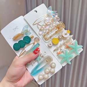 Close-up of hair clips featuring resin pearls, starfish, and glittery mermaid details
